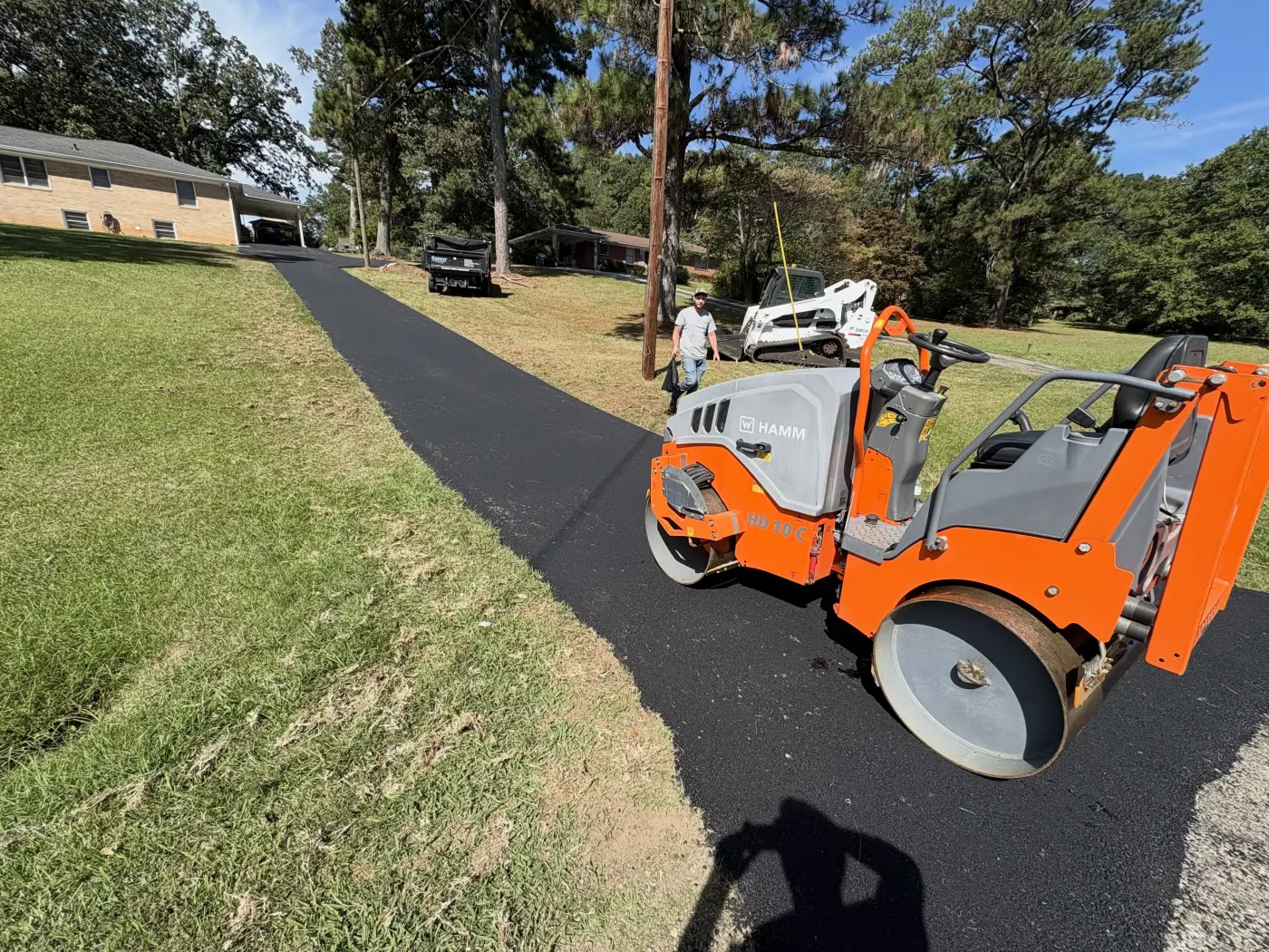 Roller compacting fresh asphalt on a residential drive